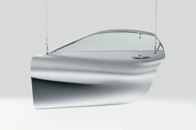 a car door hanging from two wires. 