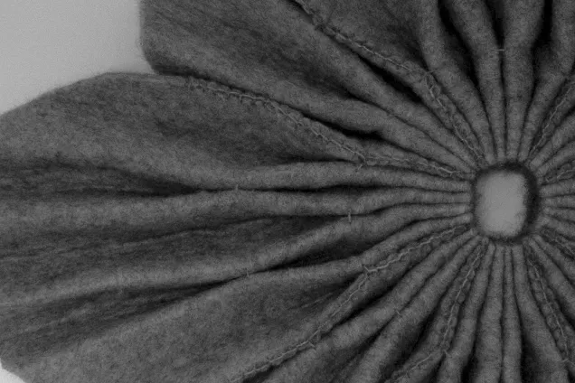felt fabric folded into the shape of a flower.