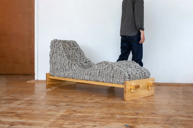 Person walking away from woolen lounge chair. Photo.
