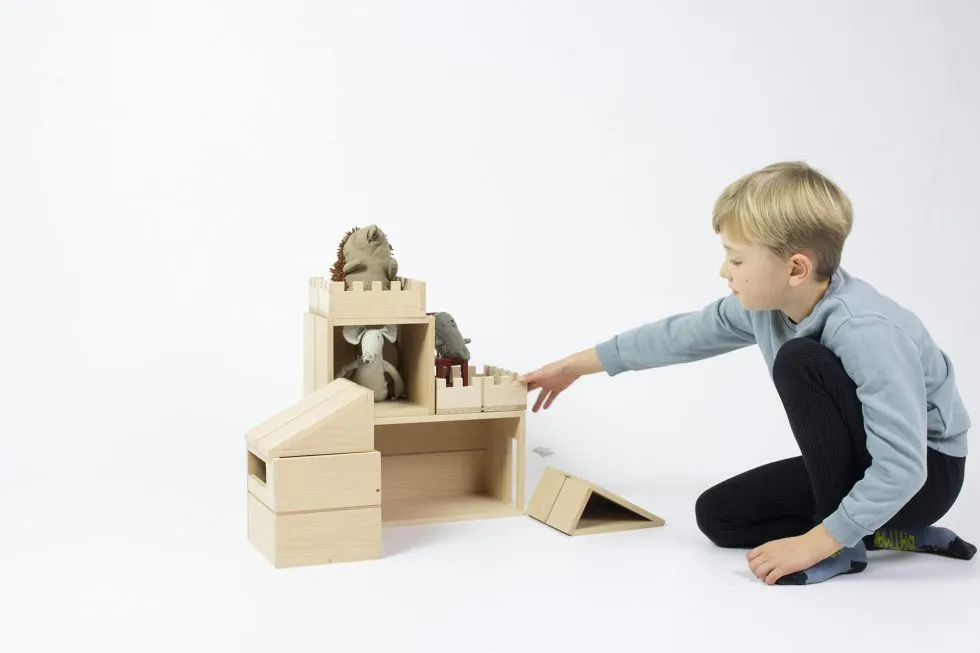 child playing with a wooden modular doll house