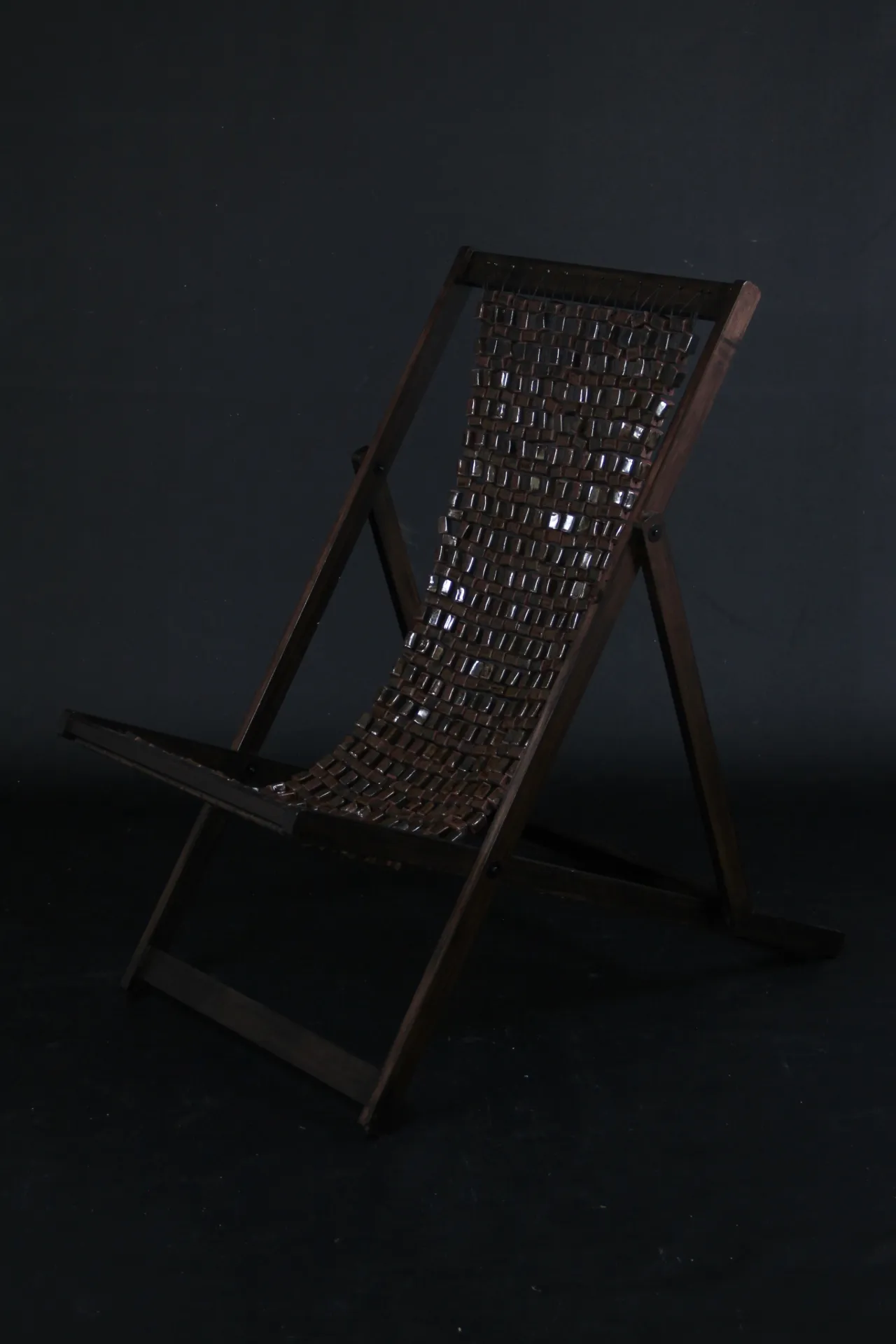 Longe chair on dark background. Photo. 