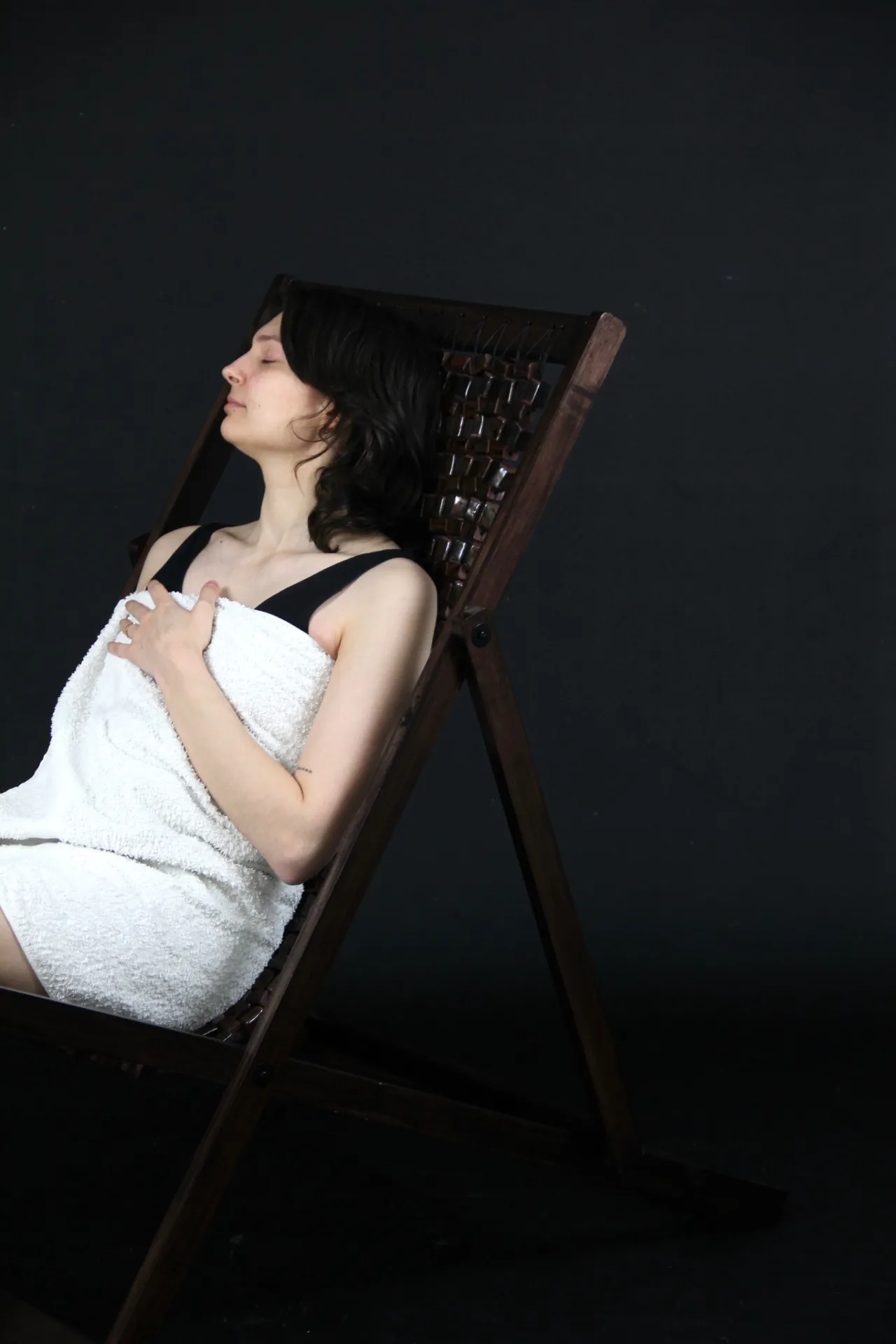 Person wearing a towel resting in the lounge chair. Photo. 