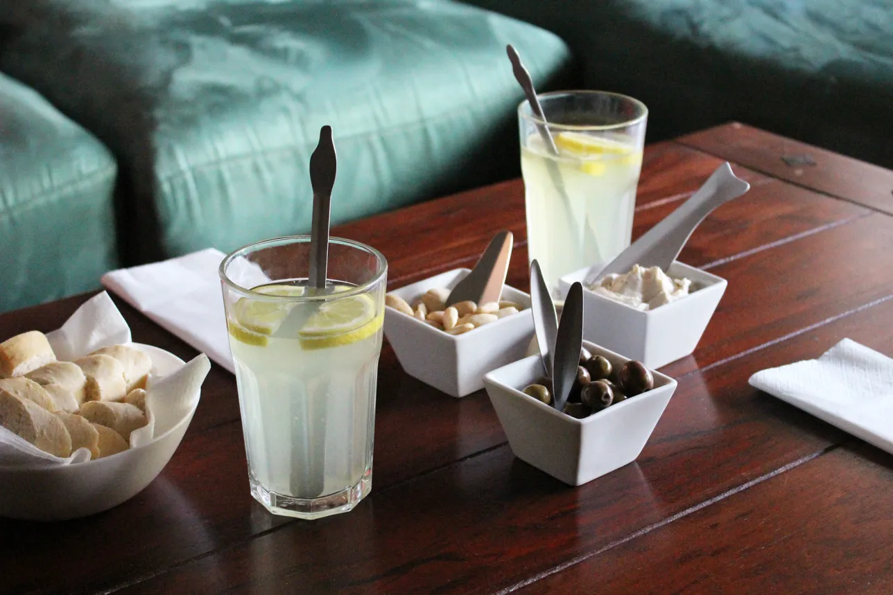 Dining table utensils in use with different snacks and drinks. Photo.